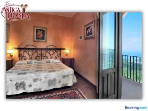 a bedroom with a bed and a balcony at Antica Filanda in Capri Leone