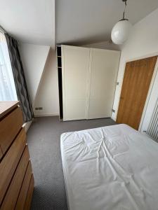 a bedroom with a white bed and a closet at Two BR Flat 5 mins walk from London eye G96 in London