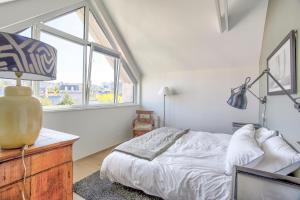 a white bedroom with a bed and a window at L'aquarium - Villa au centre d'Erquy in Erquy