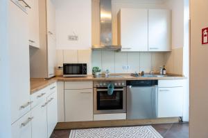 a kitchen with white cabinets and a microwave at Volante Apartment Bremen-Findorff in Bremen