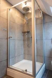 a shower with a glass door in a bathroom at Volante Apartment Bremen-Findorff in Bremen