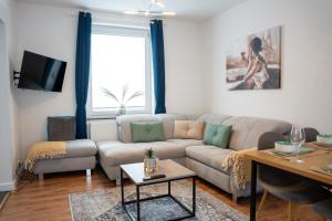 ein Wohnzimmer mit einem Sofa und einem Tisch in der Unterkunft Volante Apartment Bremen-Findorff in Bremen