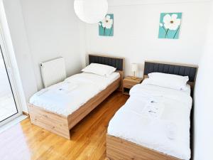 two twin beds in a room with a window at Gtrip Nea Smyrni Floor Apartment 7F in Athens