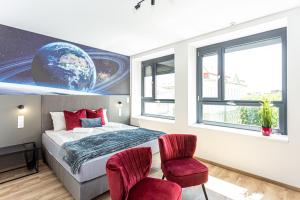 1 dormitorio con 1 cama y 2 sillas rojas en R73 Residences, en Pécs