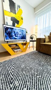 uma sala de estar com uma grande televisão numa bancada amarela em Vytauto 80 em Palanga