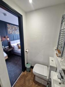 a bathroom with a toilet and a sink and a bed at The Coastal Hideaway in Bridlington