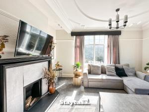 sala de estar con sofá y chimenea en Stunning 5bdr Detached King Suite Abode, en Leicester