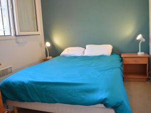 1 dormitorio con 1 cama azul y 2 almohadas en Appartement La Croix-Valmer, 2 pièces, 4 personnes - FR-1-226B-28, en La Croix-Valmer