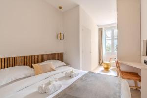 um quarto branco com 2 toalhas numa cama em NEW Luxury & Cozy Apartment - 6p em Paris