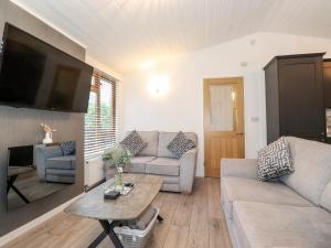 a living room with a couch and a table at Ruskin Lodge in Windermere