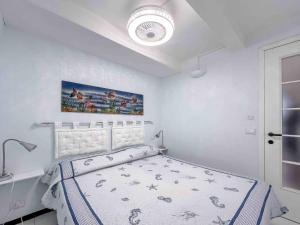 Dormitorio blanco con cama y techo en Centralissimo Bilocale a 50 mt dal mare, en Varazze