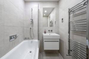 a white bathroom with a tub and a sink at Luxury Notting Hill on Canal in city of westminster trendy massive in London