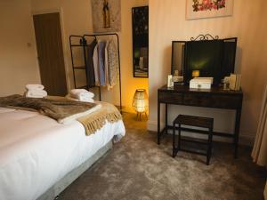 a bedroom with a bed and a desk with a television at Station House Haworth in Haworth