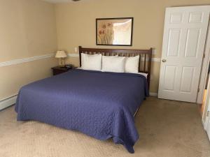 a bedroom with a large bed with a purple blanket at Acadia Village Resort in Ellsworth