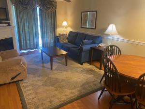 a living room with a blue couch and a table at Acadia Village Resort in Ellsworth