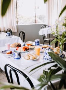 a table with plates of food and drinks on it at Hotel Novo Horizonte - By UP Hotel in Monte Sião