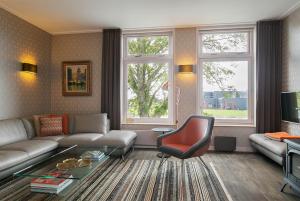 een woonkamer met een bank en een stoel bij Molepôlle 7 - Stadslogementen Franeker in Franeker