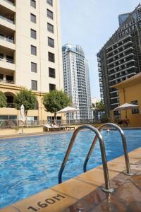 a swimming pool in a city with tall buildings at Shams JBR Hostel in Dubai