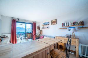 フォン・ロムー・オデイヨ・ヴィアにあるLes Eglantines - Appt vue montagneの木製デスク、窓が備わる客室です。