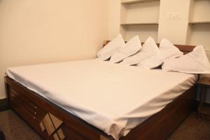 een bed met witte lakens en kussens erop bij Bhanwar VILLA HOTEL in Pāl