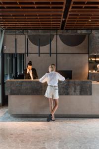 a woman is standing in front of a counter at Bellevue Hotel & Resort in Lido di Jesolo