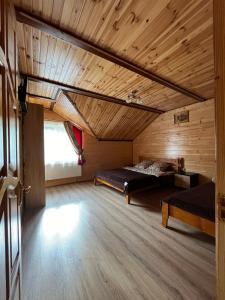 スラブスクにあるКотеджі Мелодія Карпатの木製の天井が特徴の広い客室で、ベッド2台が備わります。