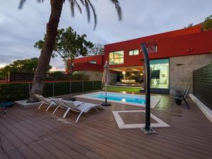 eine Terrasse mit Stühlen, einen Pool und ein Haus in der Unterkunft Salobre Golf Villas Tabaibas in Salobre