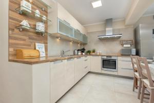 a kitchen with white cabinets and a counter top at Soft Beige Apartment Raniuszka in Warsaw by Renters in Warsaw