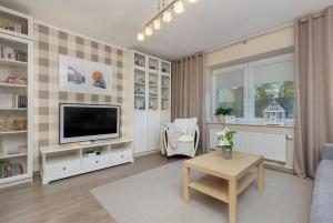 a living room with a television and a table at Soft Beige Apartment Raniuszka in Warsaw by Renters in Warsaw