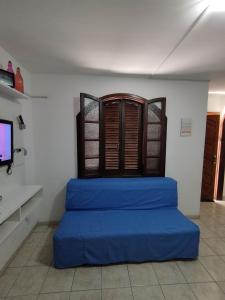 a room with a blue bed in front of a window at Seu Apto na Praia da Costa 11 Simples e Barato 2Q Não divide Completo Ar Cond Fogão Geladeira Local Excelente no Centro in Vila Velha