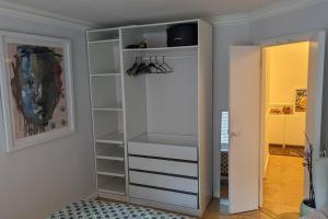 a closet with white shelves in a room at Stylish, Peaceful 2-Bed Flat with Free Parking in New Barnet