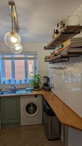 a kitchen with a sink and a washing machine at Stylish, Peaceful 2-Bed Flat with Free Parking in New Barnet