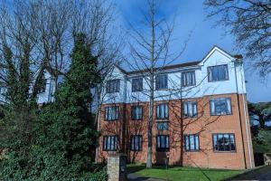 a large brick building with a tree in front of it at Stylish, Peaceful 2-Bed Flat with Free Parking in New Barnet