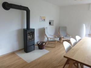a room with a stove and chairs and a table at Ferienhaus Ernas Hygge 
