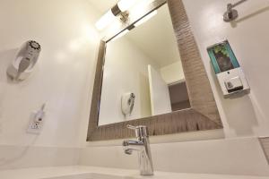 a bathroom with a mirror and a sink at Hotel 414 Anaheim in Anaheim