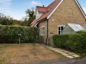 a house with a greenhouse in front of it at Cobblers Cottage in Sawston