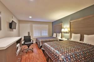 a hotel room with two beds and a chair at Hotel 414 Anaheim in Anaheim