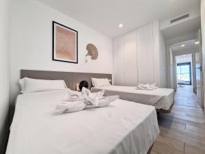 um quarto com 2 camas e lençóis brancos em Santa Rosalia Lake & Life Resort - 1310 em Torre-Pacheco