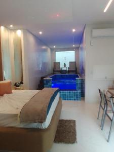 a bedroom with a bed and a swimming pool at Flash Motel (Adult Only) in São Vicente