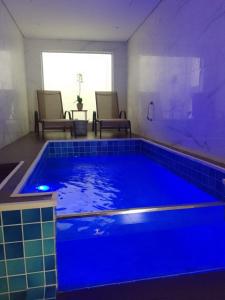Flash Motel (Adult Only) في ساو فيسينتي: حمام سباحة مع إضاءة زرقاء في الغرفة