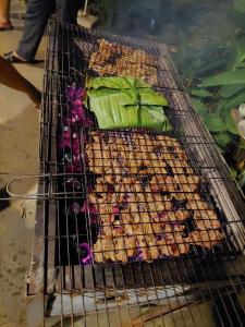 a grill with many different types of food on it at The Lazy Farm-Garden Central Room in Mewal