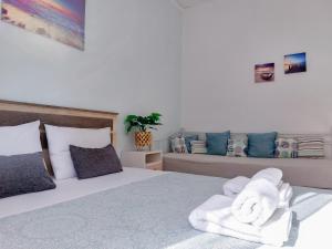 a bedroom with two beds with towels on the bed at Holiday House Heraklion in Heraklio