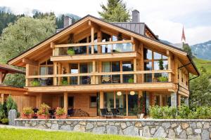 a large wooden house with glass windows at SportLodge MOUNTAIN SUITE - Alpine Apartment with Shared Pool, Whirlpool & Sauna, presented by AlpenLuxus in Kleinboden +37 photos
