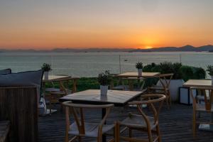 uma vista do pôr do sol de um restaurante com mesas e cadeiras em Coral Hotel Athens em Atenas