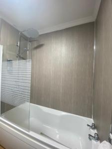 a bathroom with a bath tub with a mirror at The Woodlands - Zillo in Bishop Auckland