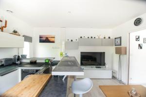 eine Küche mit weißen Schränken und einem Tisch in der Unterkunft Sable et Reflets - T2 - Centre ville d'Hossegor in Soorts-Hossegor + 5 Fotos