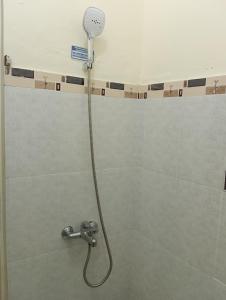 a shower with a shower head in a bathroom at Balqis Homestay Syariah III Nagari Salo Kec Baso Kab Agam in Baso