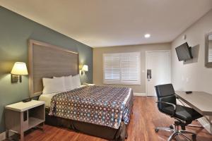 a hotel room with a bed and a desk at Hotel 414 Anaheim in Anaheim