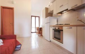 uma pequena cozinha com electrodomésticos brancos e um quarto em 1 Bedroom Gorgeous Apartment In Costa Rei -ca- em Monte Nai