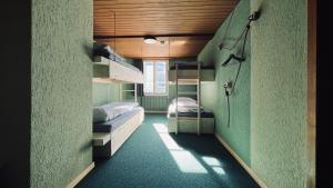 a small room with two bunk beds in it at Alpina Einhorn - Self-Check-In in Wolfenschiessen